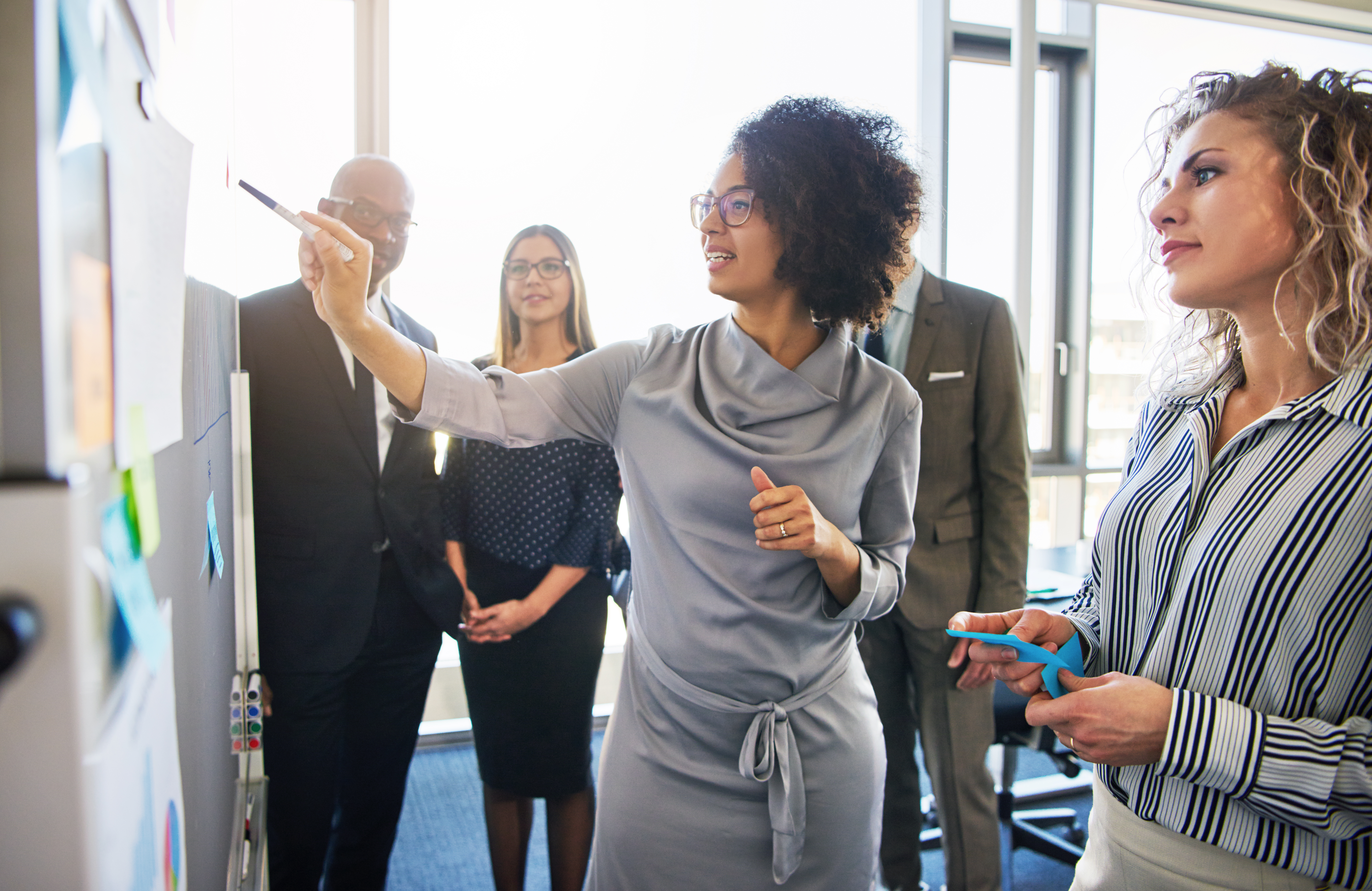 professional woman pointing at a whiteboard